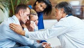 Doctor comforting family