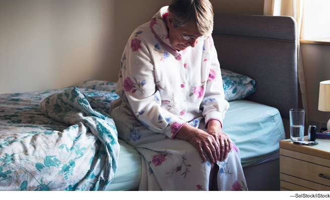 Woman sitting on side of bed