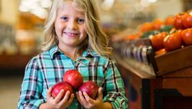 Little girl holding apples