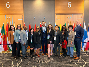 Luke Davis, board members, and UN liaisons at the international member reception in front of flags.