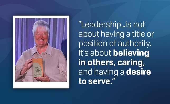 Carol Huston with her Mary Tolle Wright award with a quote beside the photo: "Leadership...is not about having a title or position of authority. It